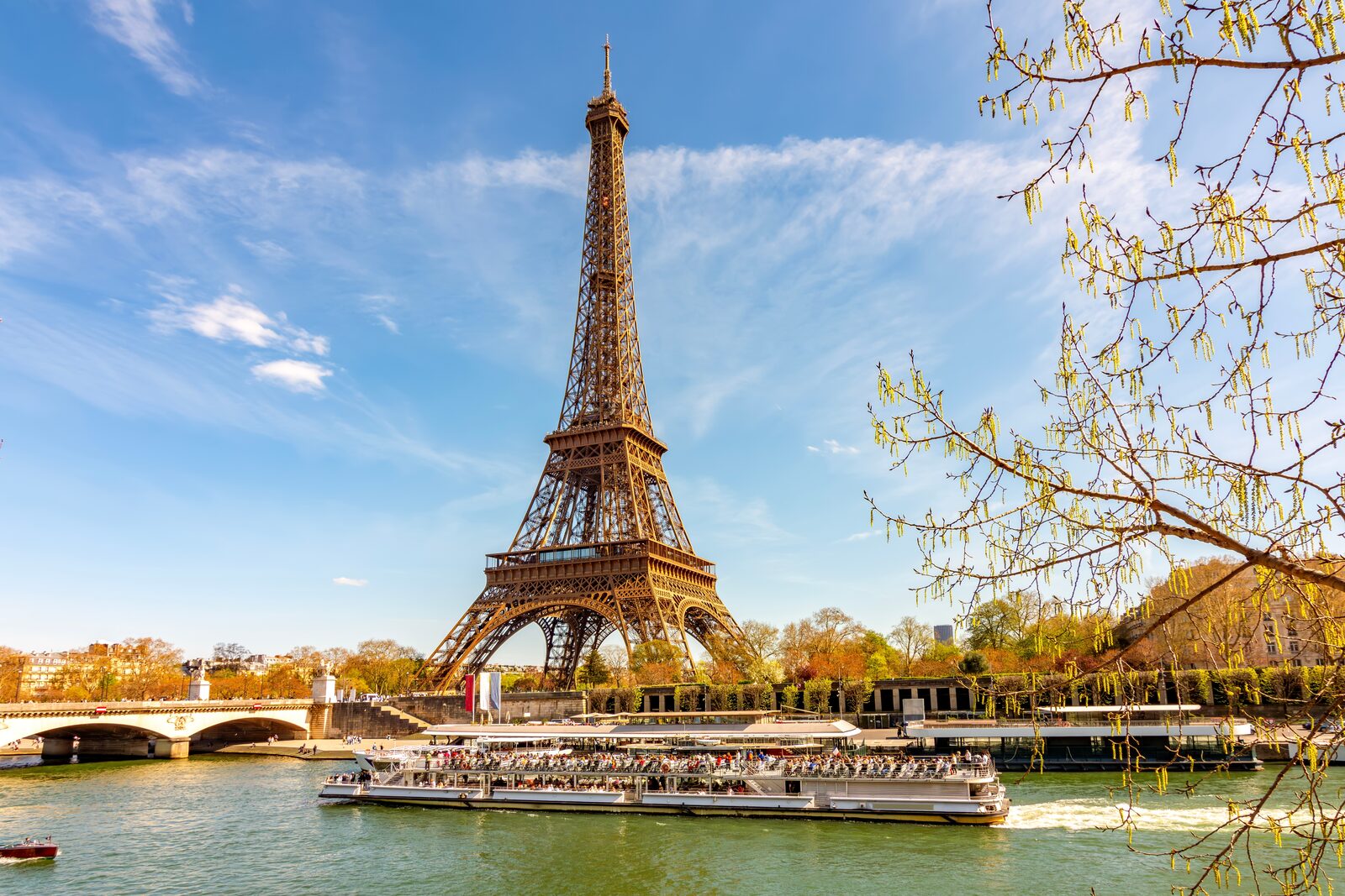 A sightseeing boat on the Seine passing Paris landmarks at dusk