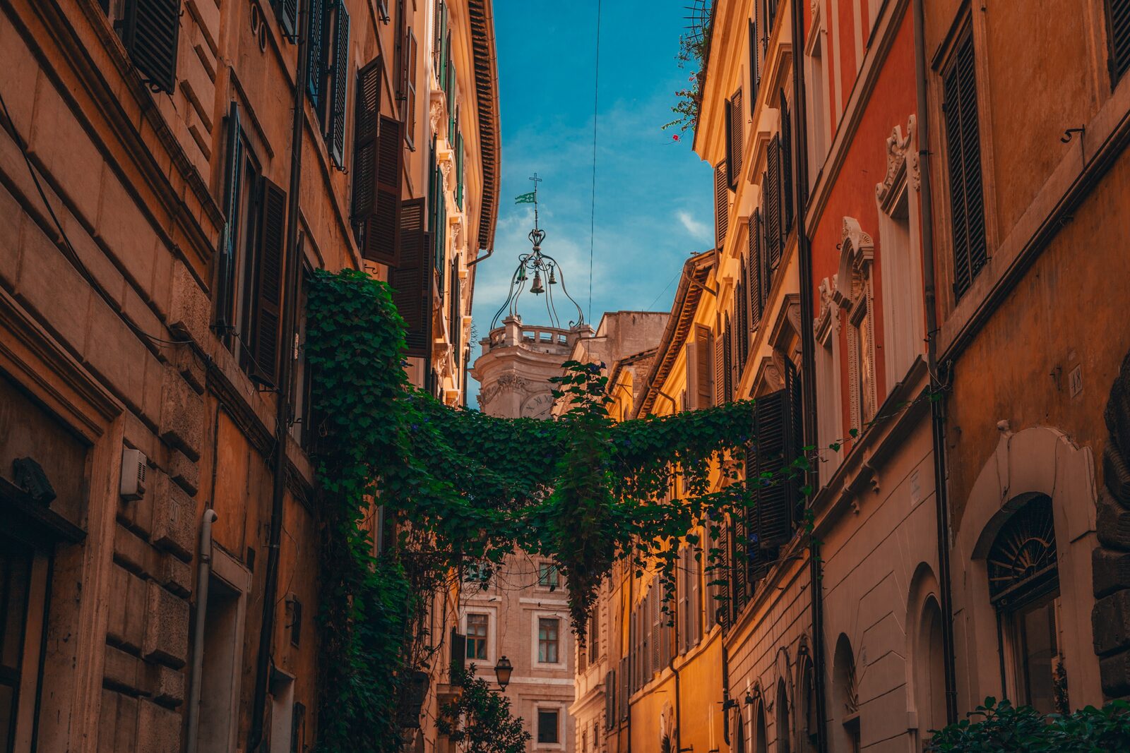 A cobblestone lane lined with ivy-covered buildings in Rome's Trastevere neighborhood
