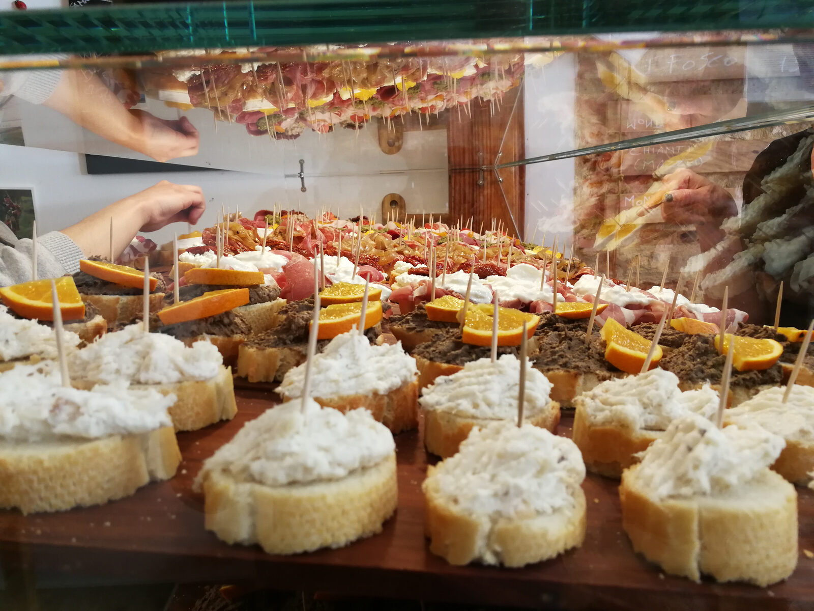 A counter of Venetian cicchetti small plates with a glass of wine