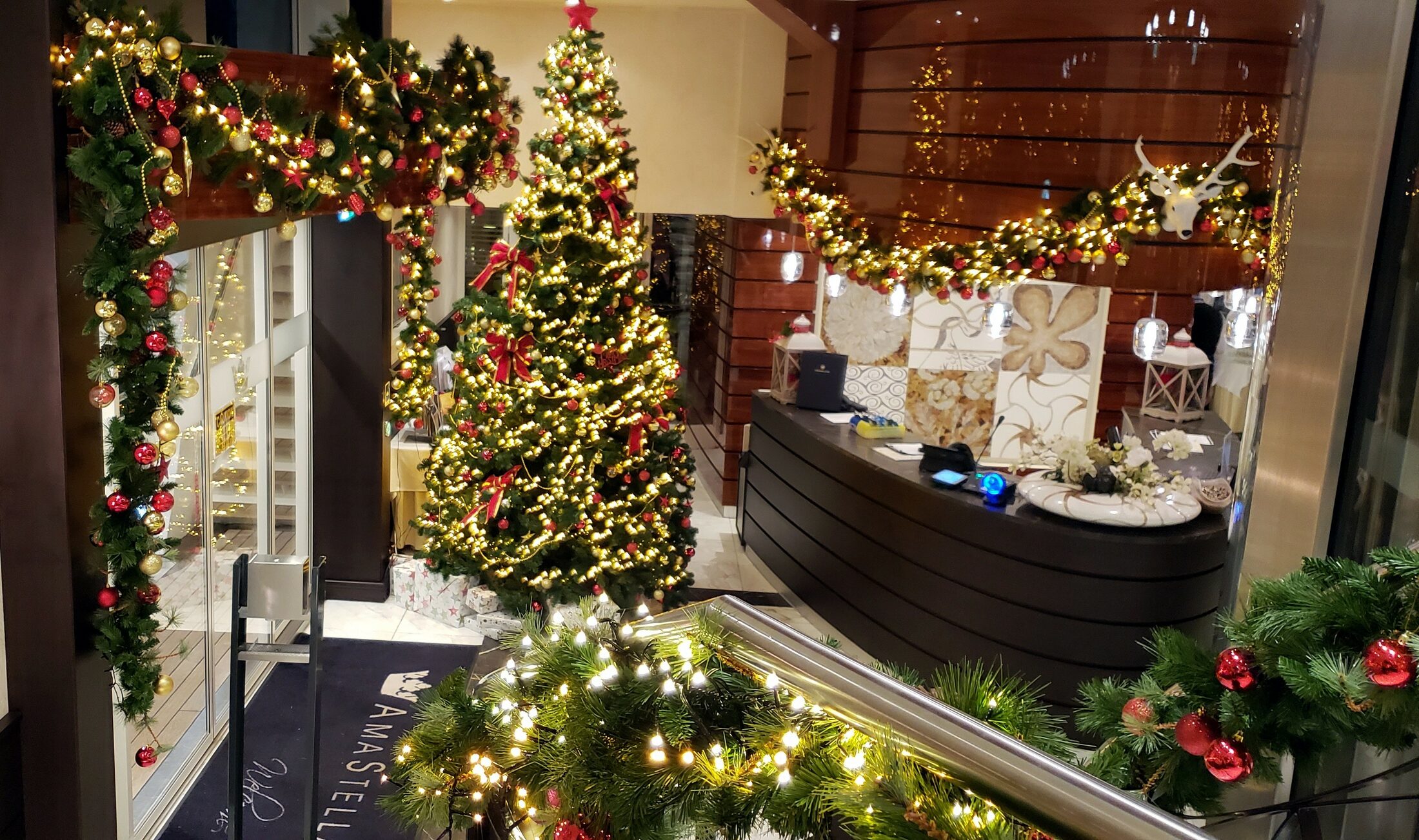 The two-level atrium of AmaWaterways' AmaStella decked out for the holidays with a Christmas tree, garlands and twinkling lights